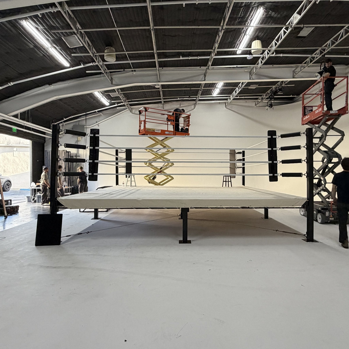 PROLAST boxing ring with a white canvas on its steel platform in a white studio