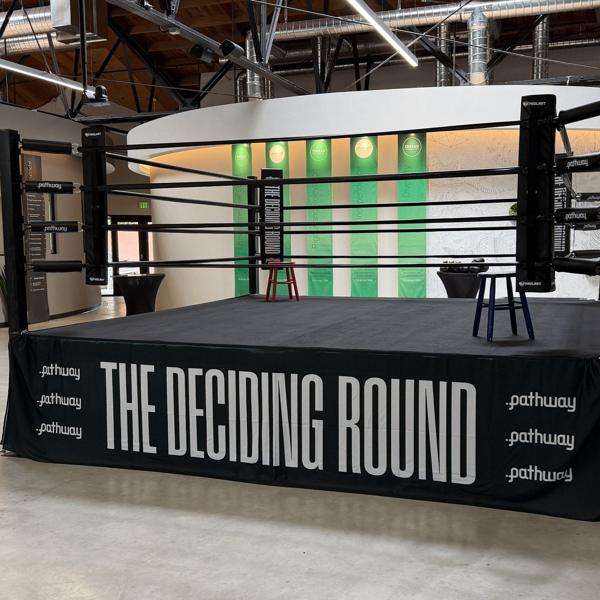 PROLAST boxing ring with black ropes and a custom printed skirt, set up for an event