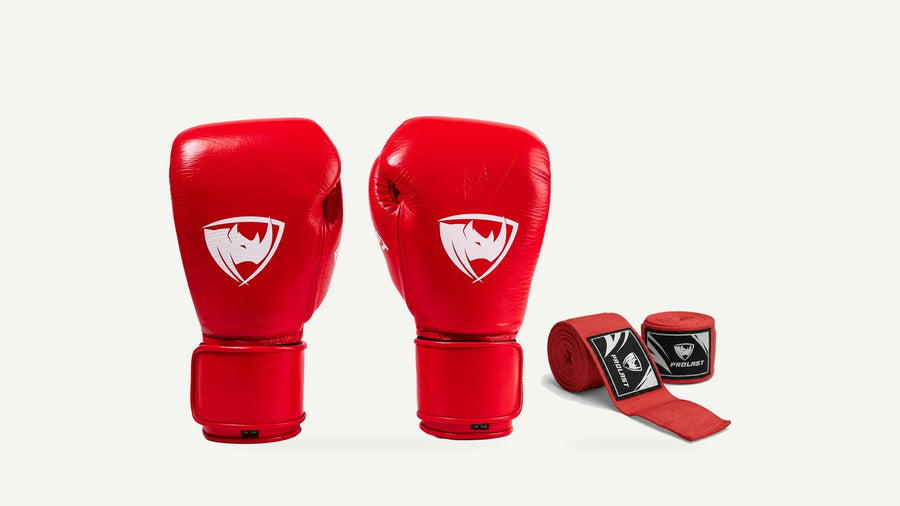 A pair of crimson red PROLAST PG Professional boxing gloves next to a set of red PROLAST hand wraps