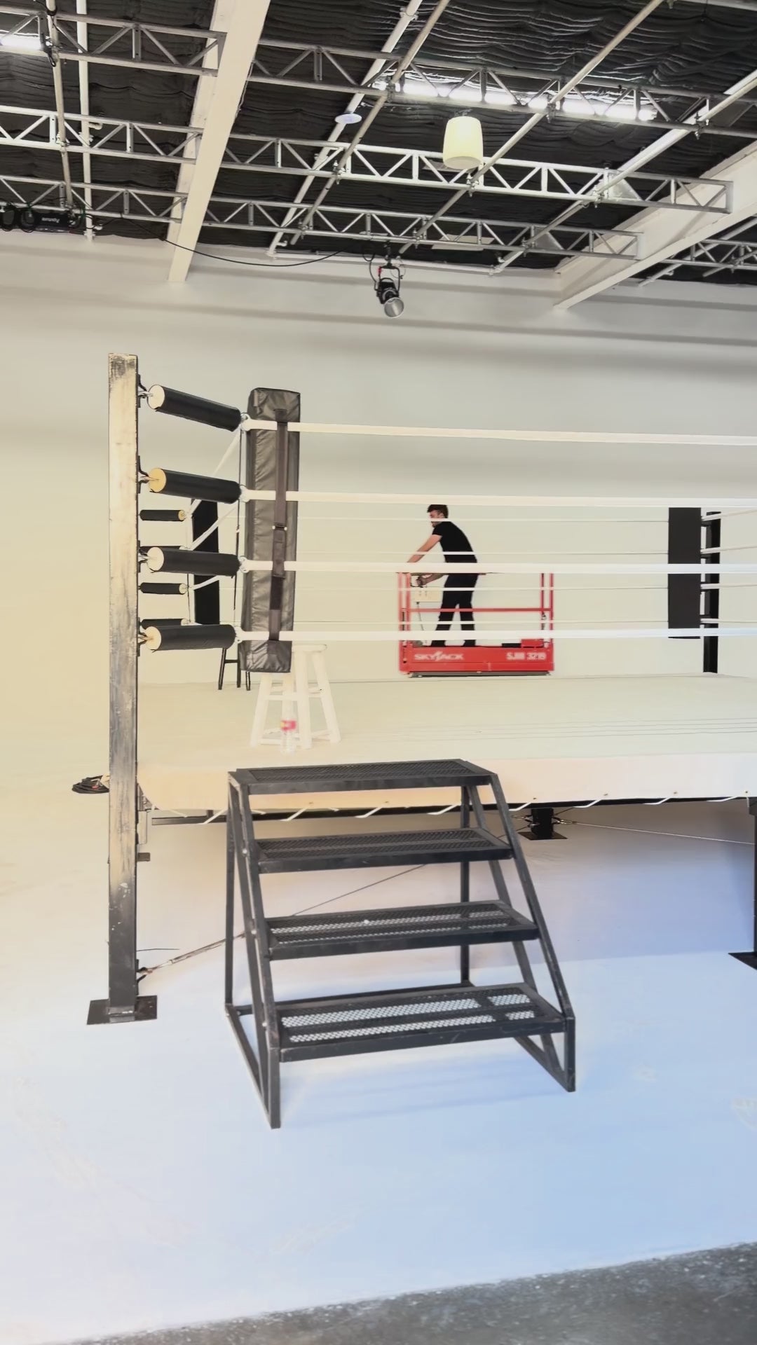 PROLAST boxing ring with steel stairs being set up in a white studio