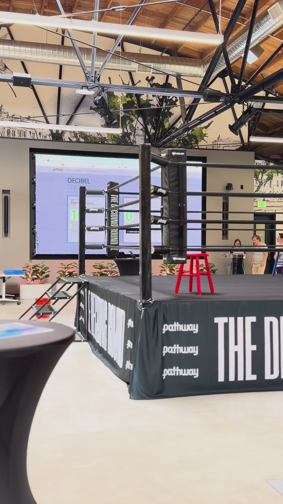PROLAST boxing ring with black ropes and a printed skirt in an event hall