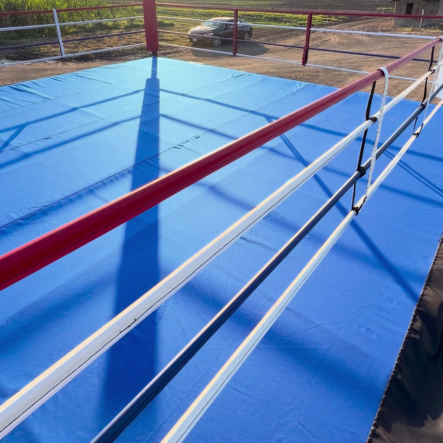 Corner of a PROLAST boxing ring with a blue canvas outdoors in the sun