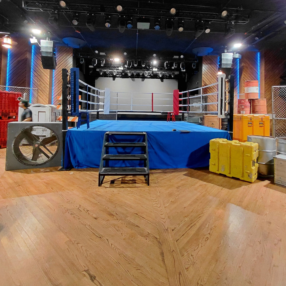 PROLAST boxing ring with a blue skirt and stairs on a film set