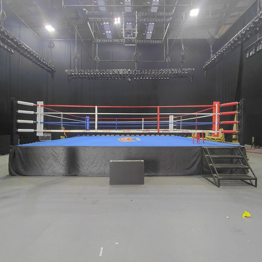 PROLAST boxing ring with red, white and blue ropes and stairs in a black studio