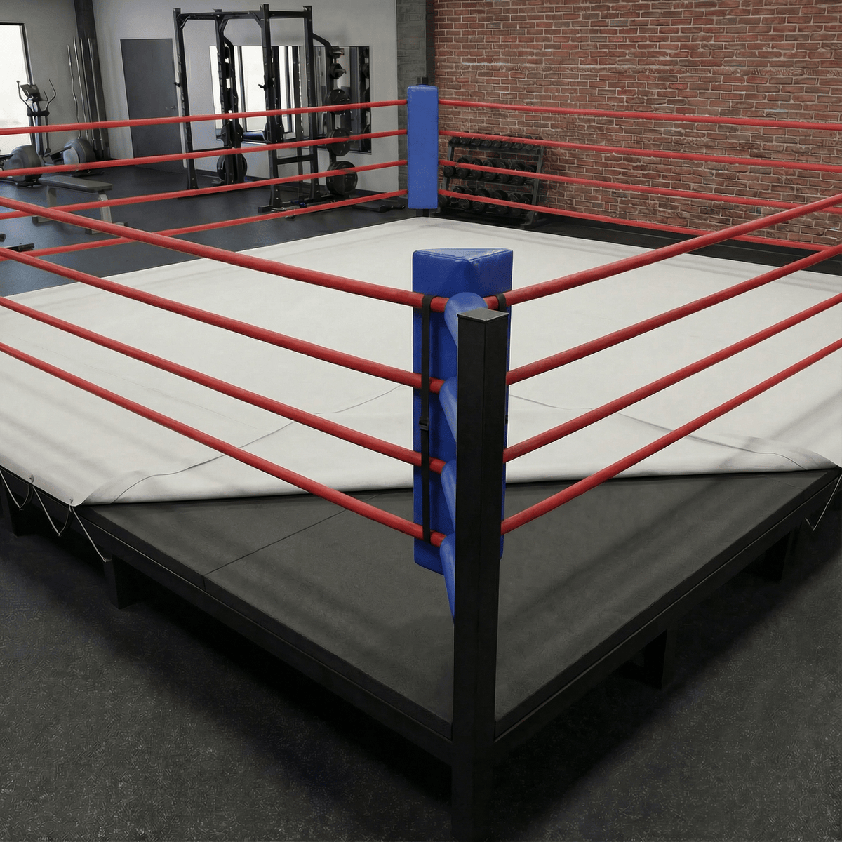 PROLAST boxing ring padding under a white canvas on a ring with red ropes and blue corner pads, one corner folded back