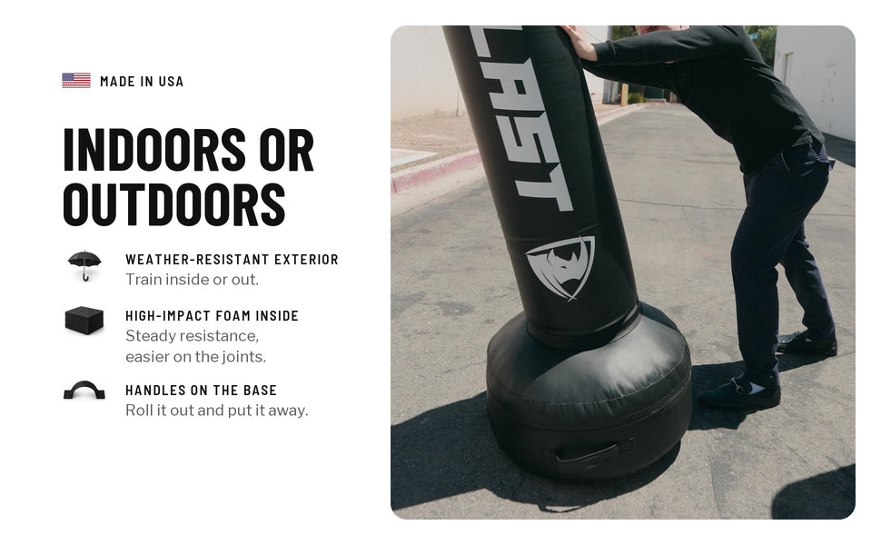 Indoors or outdoors: a person leaning on a black PROLAST freestanding bag outside. Weather-resistant exterior, high-impact foam inside, handles on the base