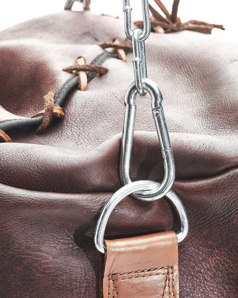 The top of a brown leather PROLAST heavy bag with tan trim: lacing, chain and D-ring