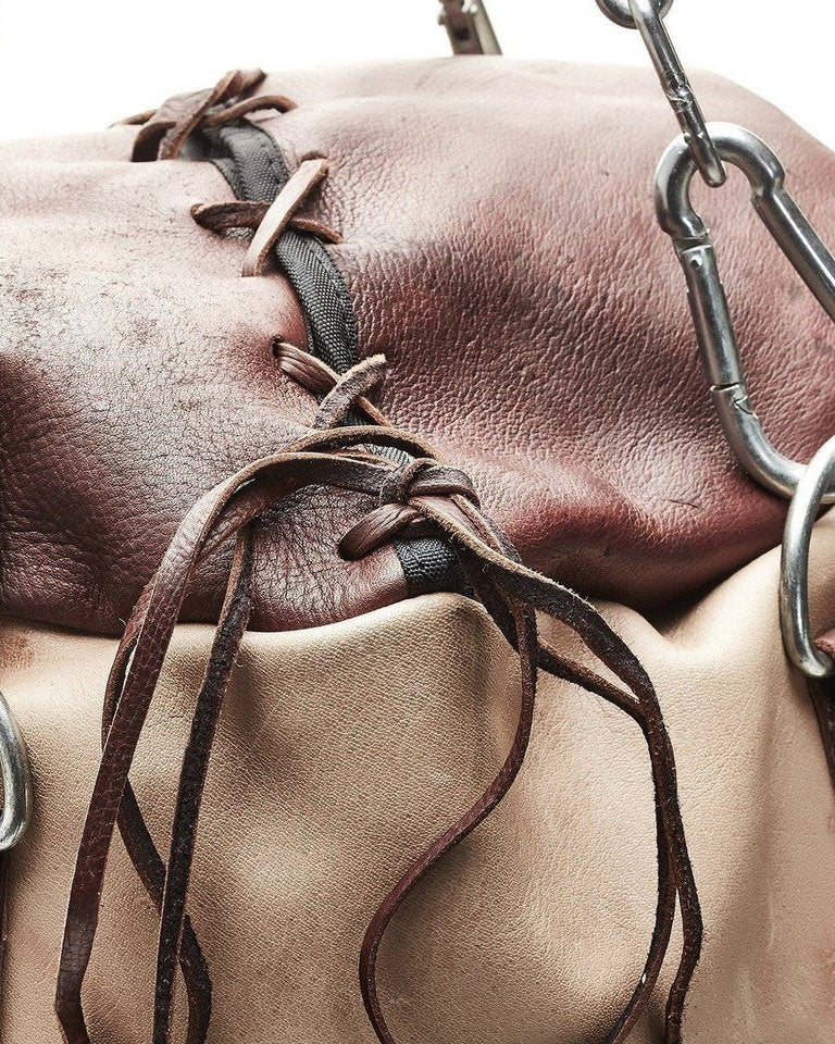 Leather lace tied at the top of a cream and brown PROLAST leather heavy bag