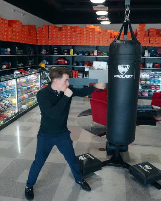 A man jabbing and punching a black 4ft PROLAST heavy bag on a bag stand