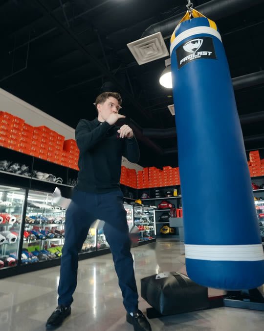 A man punching, then high-kicking, a blue 5ft PROLAST heavy bag